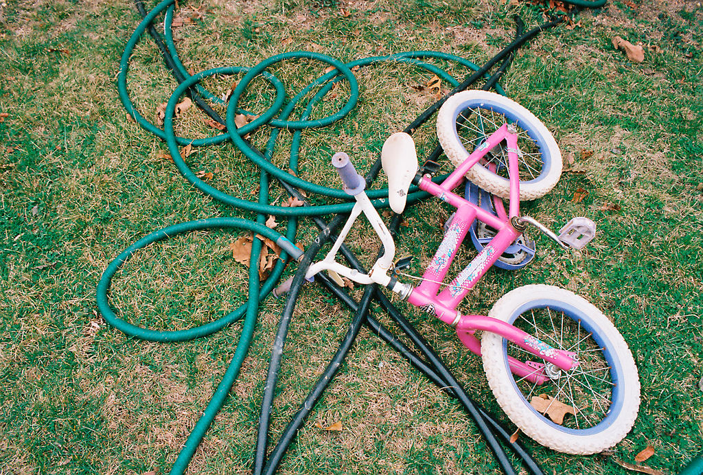 A child’s bike lies in the grass